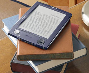 Lector de libros electrónicos sobre una pila de libros impresos